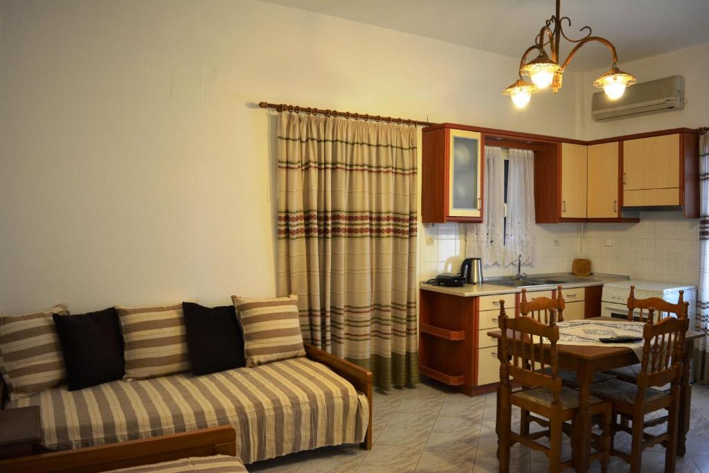 迈加洛丘里日出一室公寓式酒店的带沙发和桌子的客厅以及厨房。