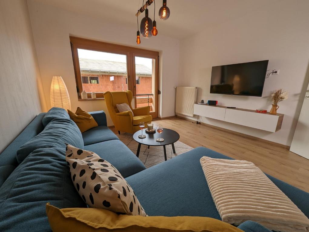 德布里阿赫Angerpartments-Sonnige große Wohnung mit Balkon und kostenlosen Parkplatz的客厅配有蓝色的沙发和电视