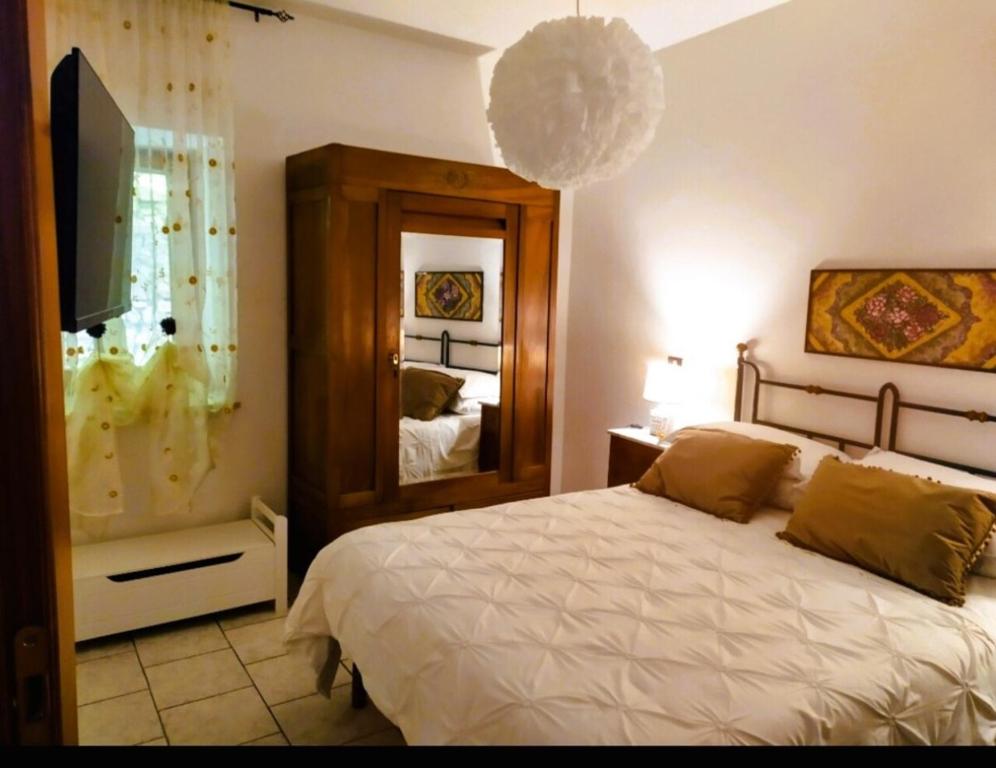 斯波莱托Mameli Suite的一间卧室配有一张大床和镜子
