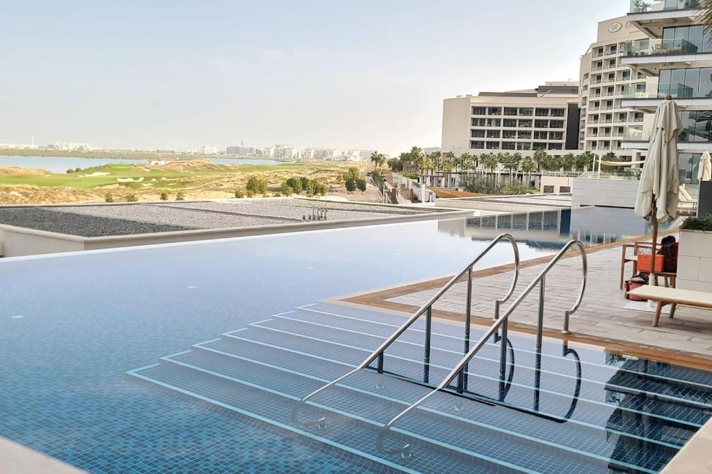 阿布扎比Luxury apartment in Yas Island的大楼内的一个蓝色海水游泳池