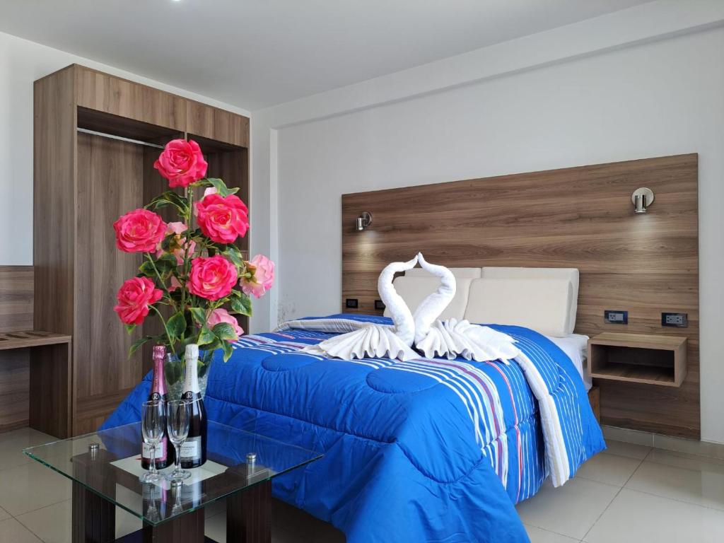 阿雷基帕Hoteles Gutiérrez Mansión的一间卧室配有一张带天鹅和玫瑰的床