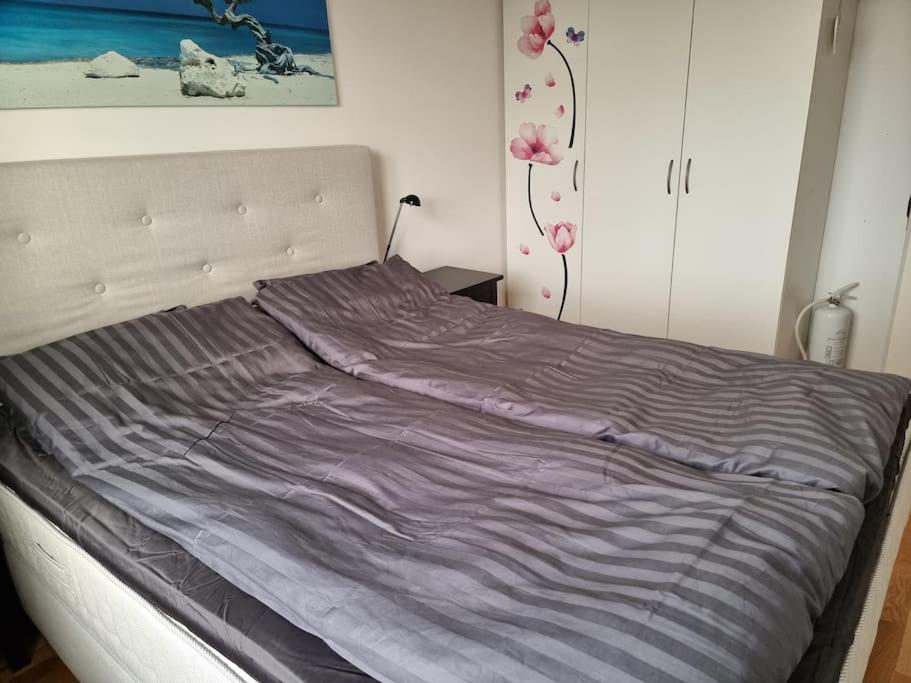 斯特伦斯塔德Trevlig lägenhet nära Strömstad centrum的卧室里一张带紫色毯子的床