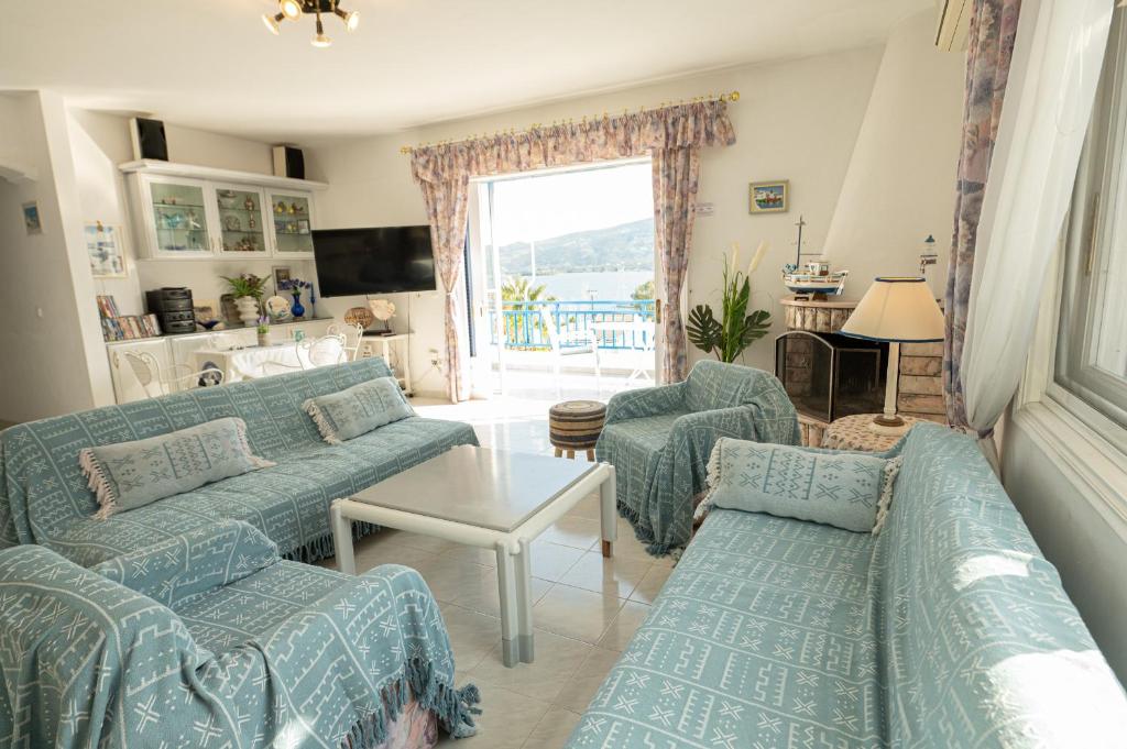 波罗斯Rigos House at Askeli beach, Poros island的客厅配有蓝色的沙发和桌子