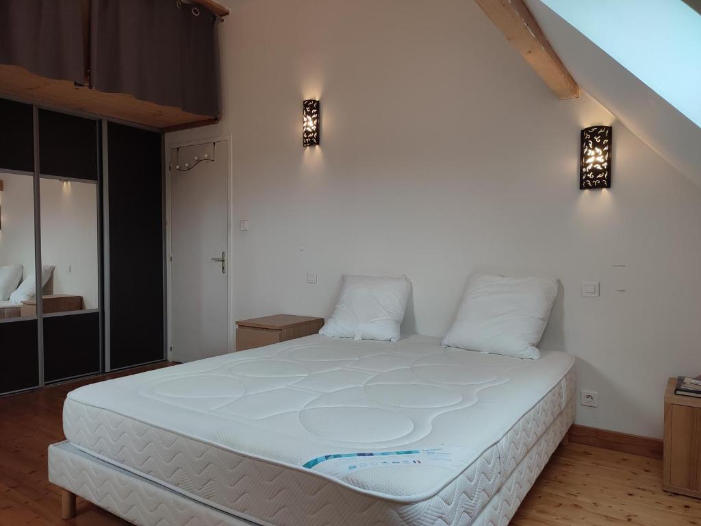 RullyLe Clos du Château的卧室配有一张带两个枕头的大白色床