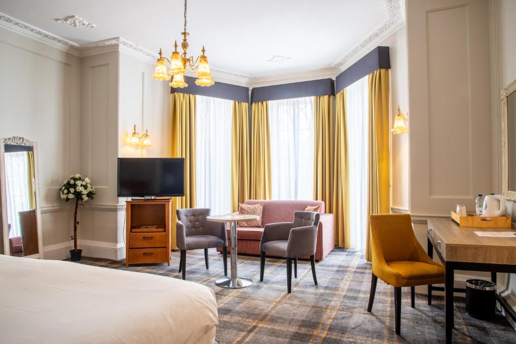 布里斯托阿诺斯庄园酒店的酒店客房带一张床、一张桌子和椅子