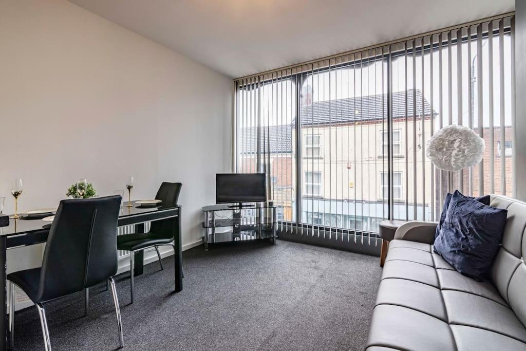 伊斯特伍德Modern flat in Eastwood Town centre的客厅配有沙发和书桌及电视
