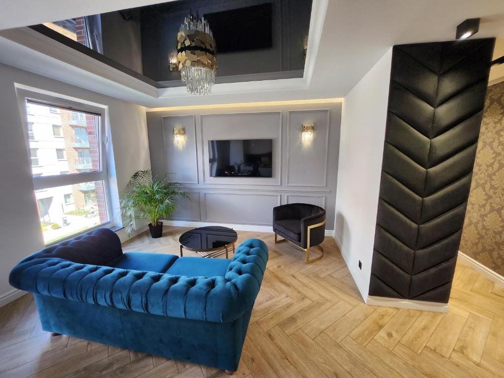 格但斯克Marina Apartments的客厅配有蓝色的沙发和电视