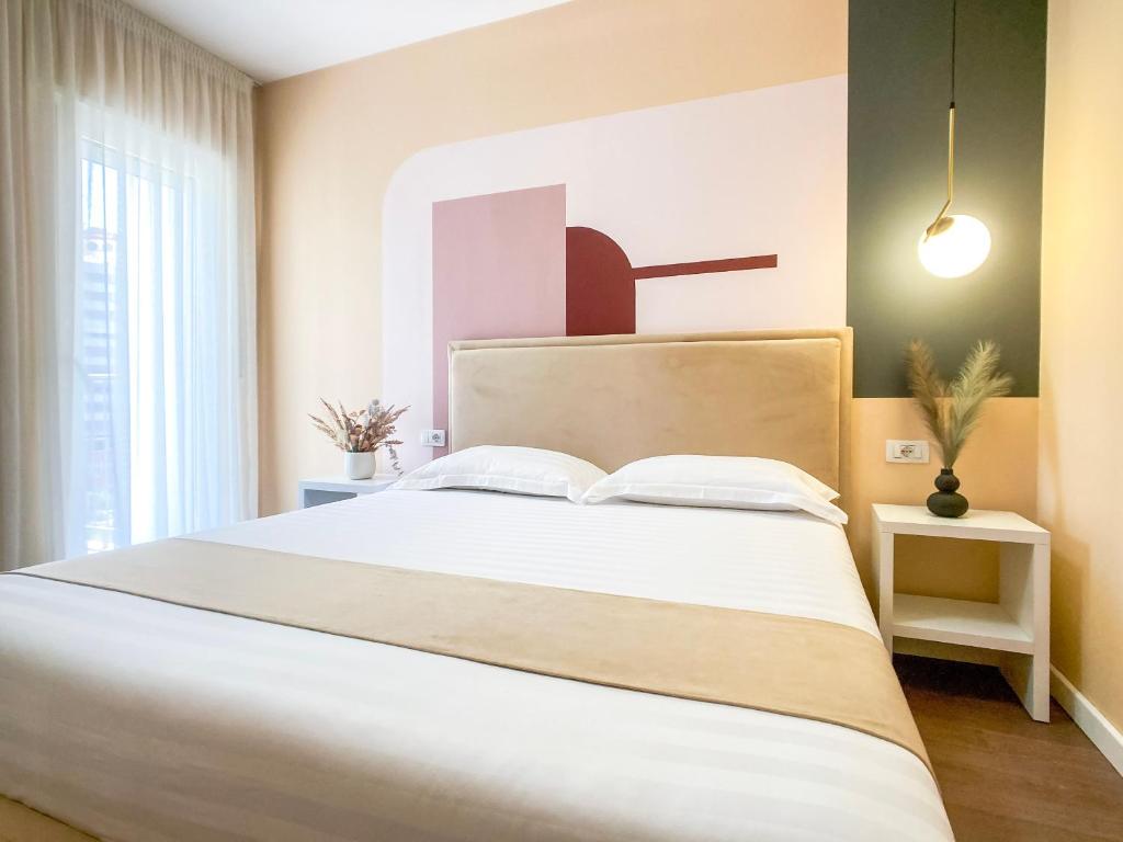 都拉斯Phi Apartments 1 min from the beach - New Additions的一间卧室配有一张带白色床单的大床