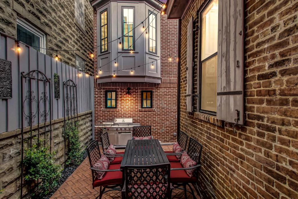 萨凡纳The Lyons House - Luxe Historical Home - Parking Included的一个带桌椅的庭院和一个阳台