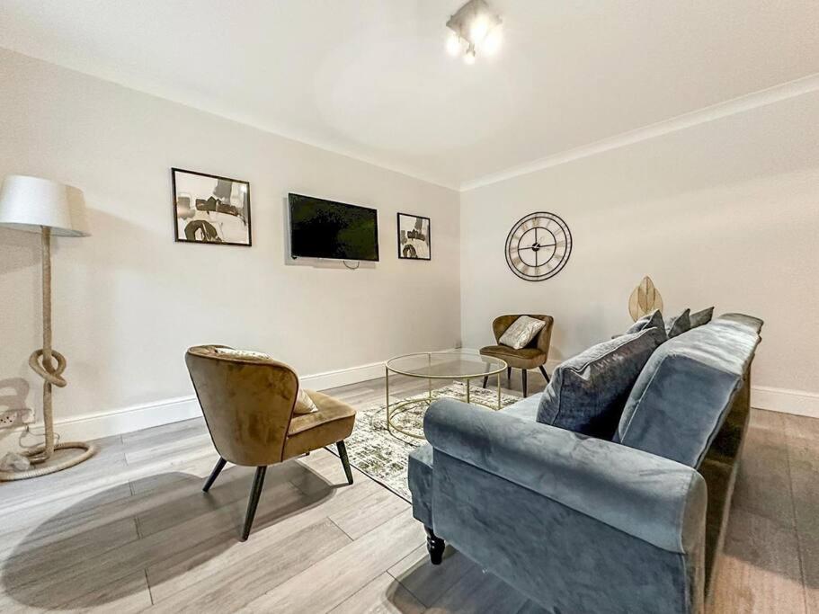 伦敦New Cosy Luxury 3 Bedroom House in Battersea London的客厅配有蓝色的沙发和椅子