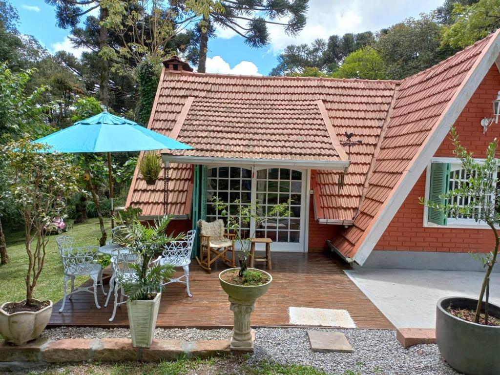 格拉玛多Chalé São Rafael - Recanto da Natureza的房屋设有带遮阳伞的庭院