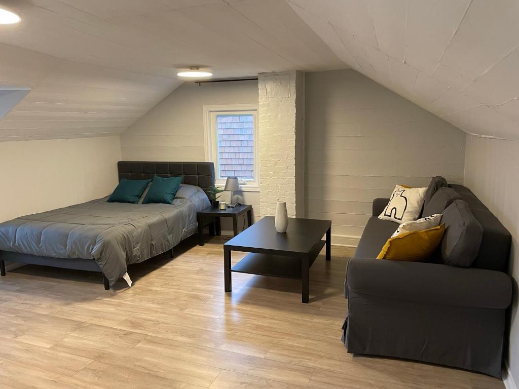 多伦多3-Bedroom House in Little Italy Downtown-Free Parking的一间卧室配有一张床、一张沙发和一张桌子