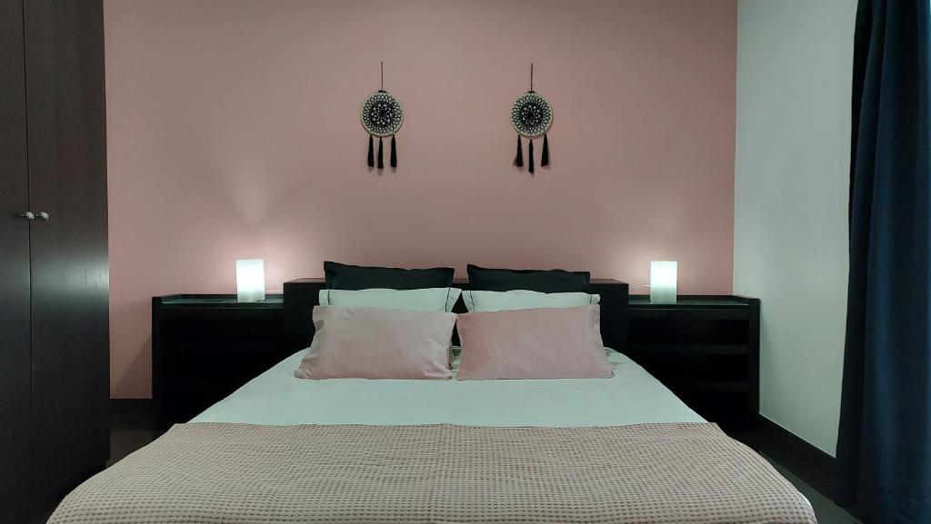 Lajes das FloresRetiro das Camélias的卧室配有一张带两盏灯的墙壁床。