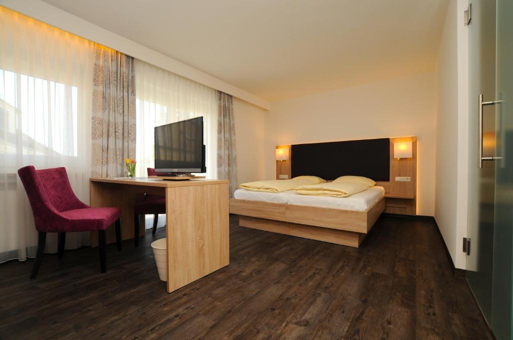 泰特南里特尔酒店的一间卧室配有一张床、一张书桌和一台电视