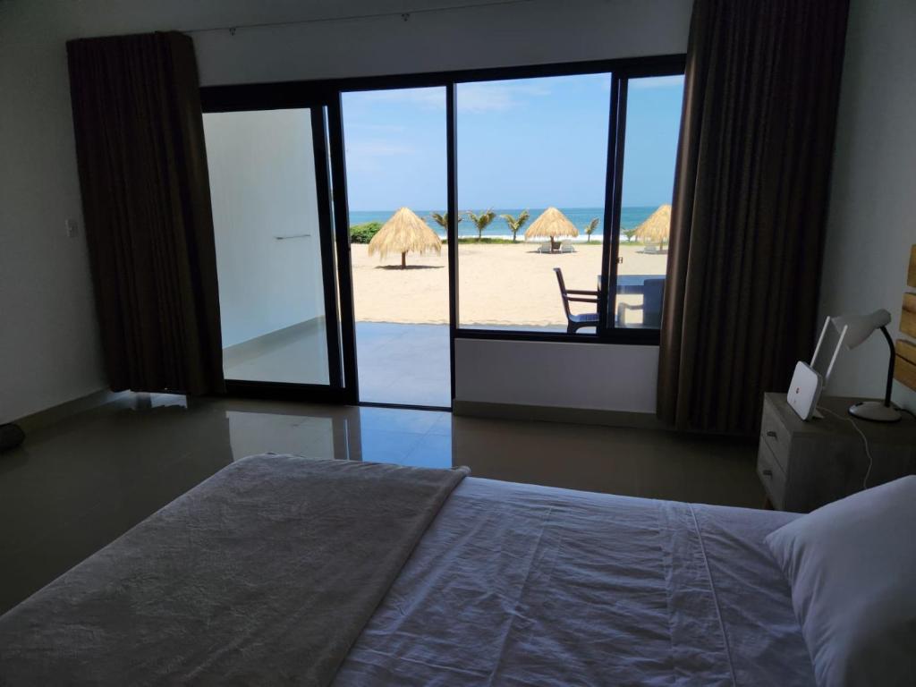 卡诺阿斯德蓬萨尔Las Hamacas的一间卧室配有一张床,享有海滩美景