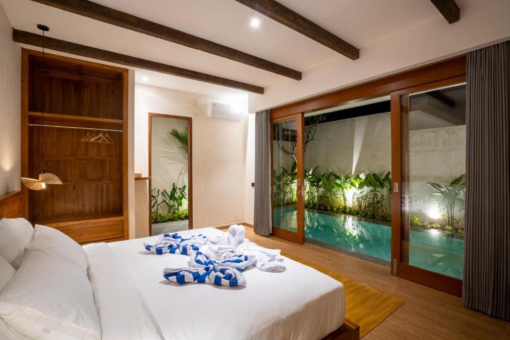 乌鲁瓦图Atania Villa's Bingin的一间卧室设有一张床和一个游泳池