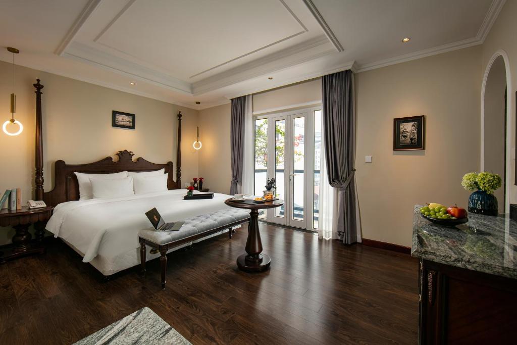 河内La Mejor Hotel & Sky Bar的一间卧室配有一张床、一张桌子和一个窗户。