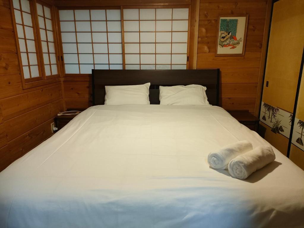 白马村Hakuba Matata Apartment的一张位于房间的床,上面有两条滚毛巾