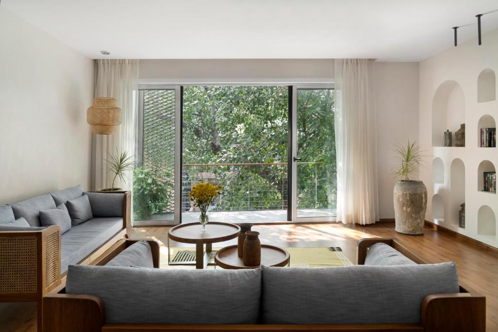 新德里Bungalow 157的带沙发和大窗户的客厅