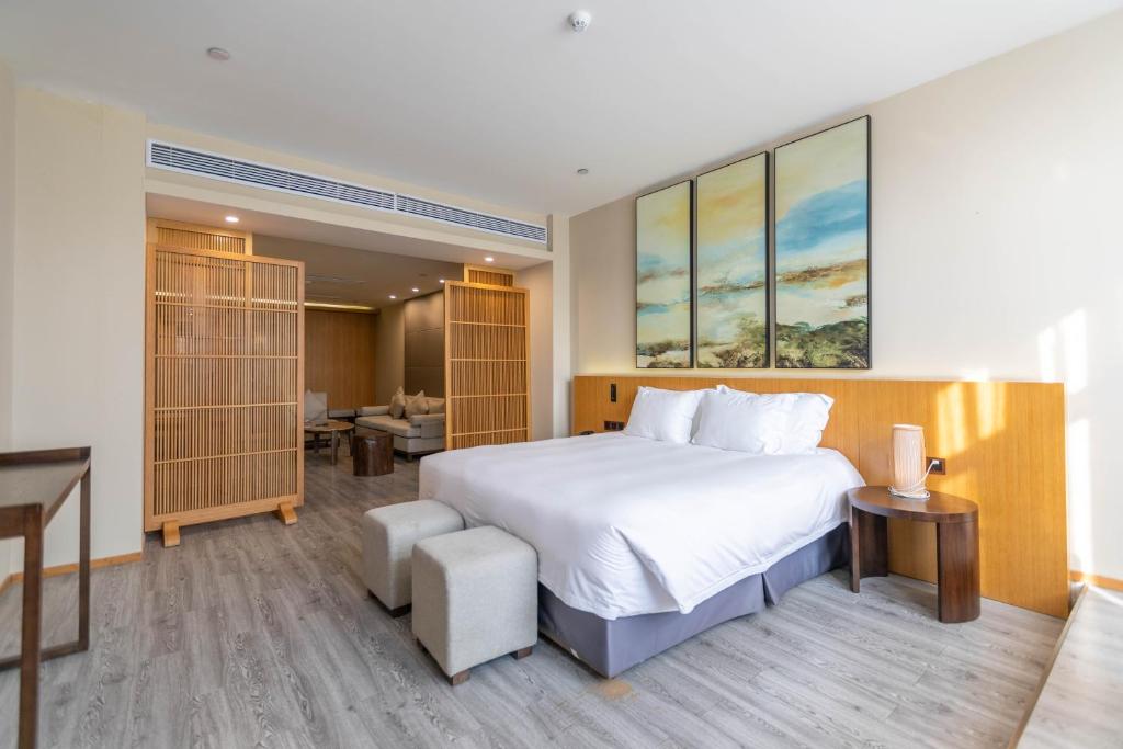 杭州杭州西溪南庐君亭酒店的卧室配有一张白色大床和一张书桌