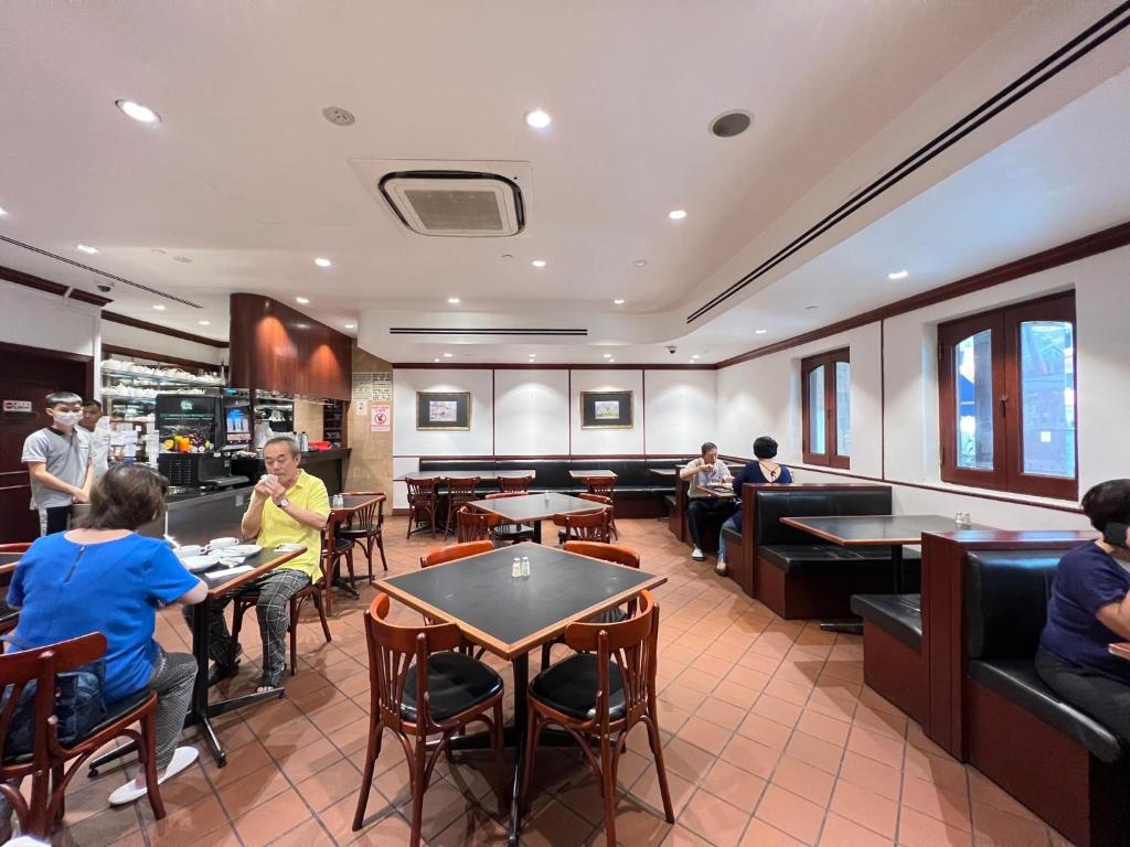 新加坡Park View Hotel的一间餐厅,人们坐在房间里桌子旁