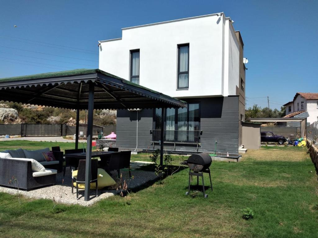 安塔利亚Sakın bir ortamda 3 odalı villa的房屋设有带桌子和烧烤架的庭院