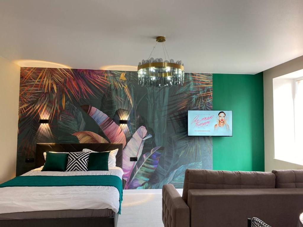 乌拉尔斯克Terracotta & Rooms комфортная студия для отдыха的一间带沙发和壁画墙的卧室