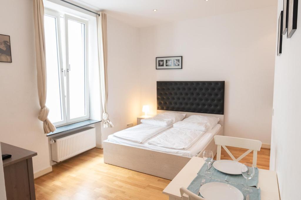 美因河畔法兰克福Charming Apartments Frankfurt City的白色卧室配有床和桌子