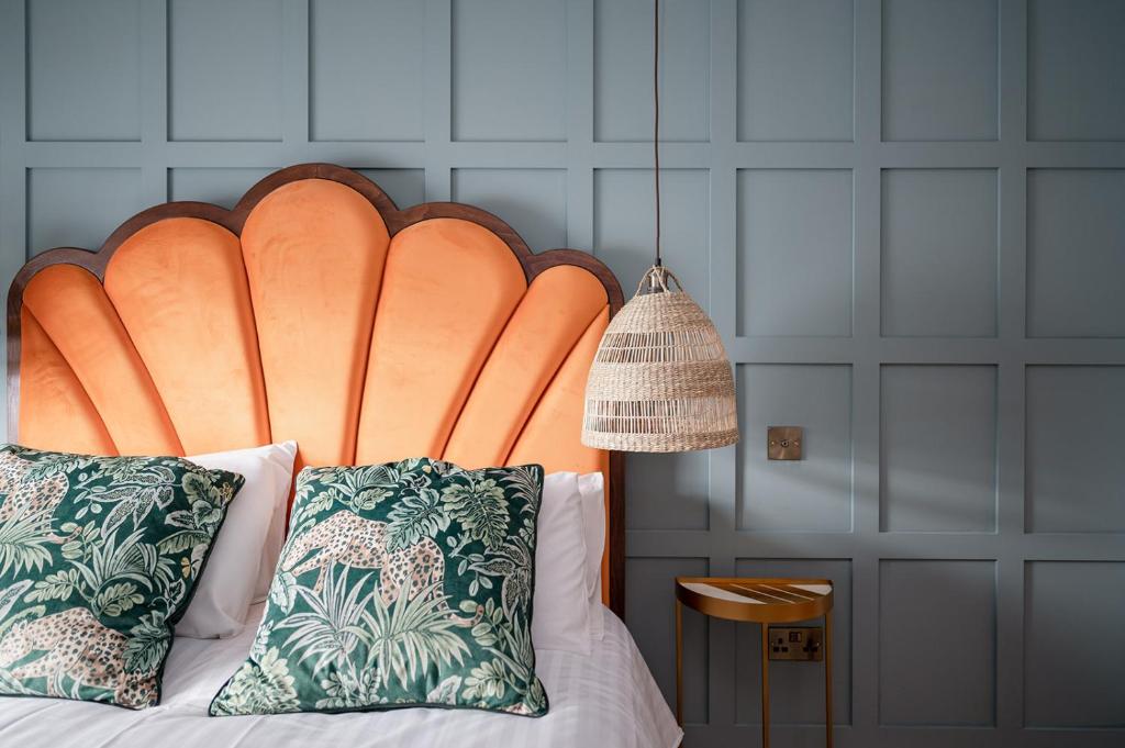 金尤西The Seelies - Luxury Aparthotel - By The House of Danu的一张带两个枕头的大型橙色床头板的床