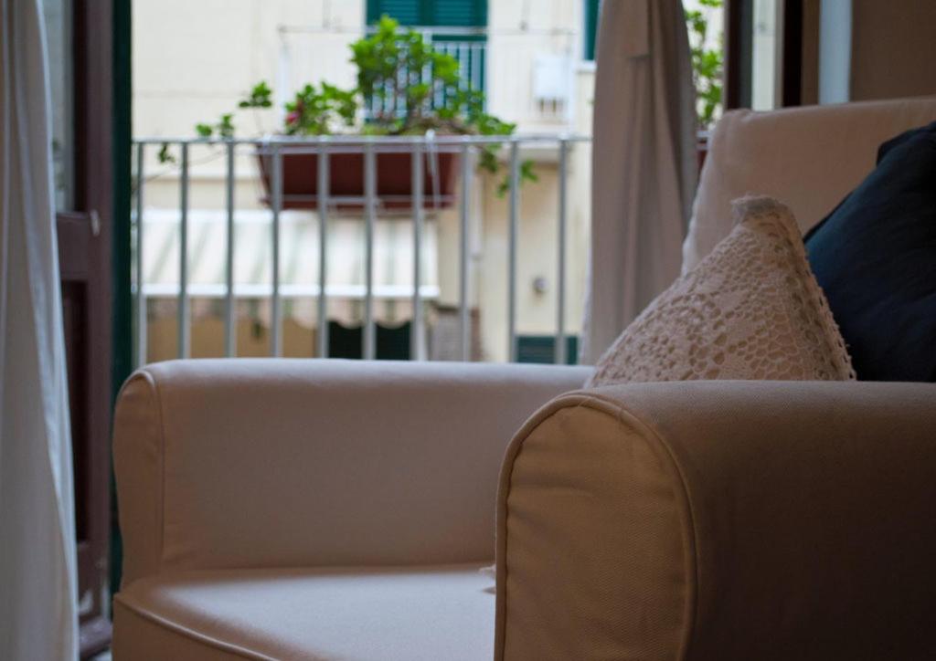 特拉尼B&B Porto Trani的阳台上的沙发上摆放着枕头和植物