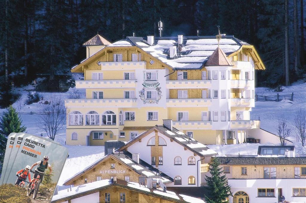 伊施格尔Hotel Garni Waldschlössl的一座白色的大建筑,上面有雪