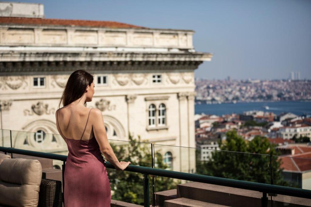 伊斯坦布尔伊斯坦布尔凯悦公园酒店 - 马茨卡帕拉斯的穿裙子的女人,眺望着城市