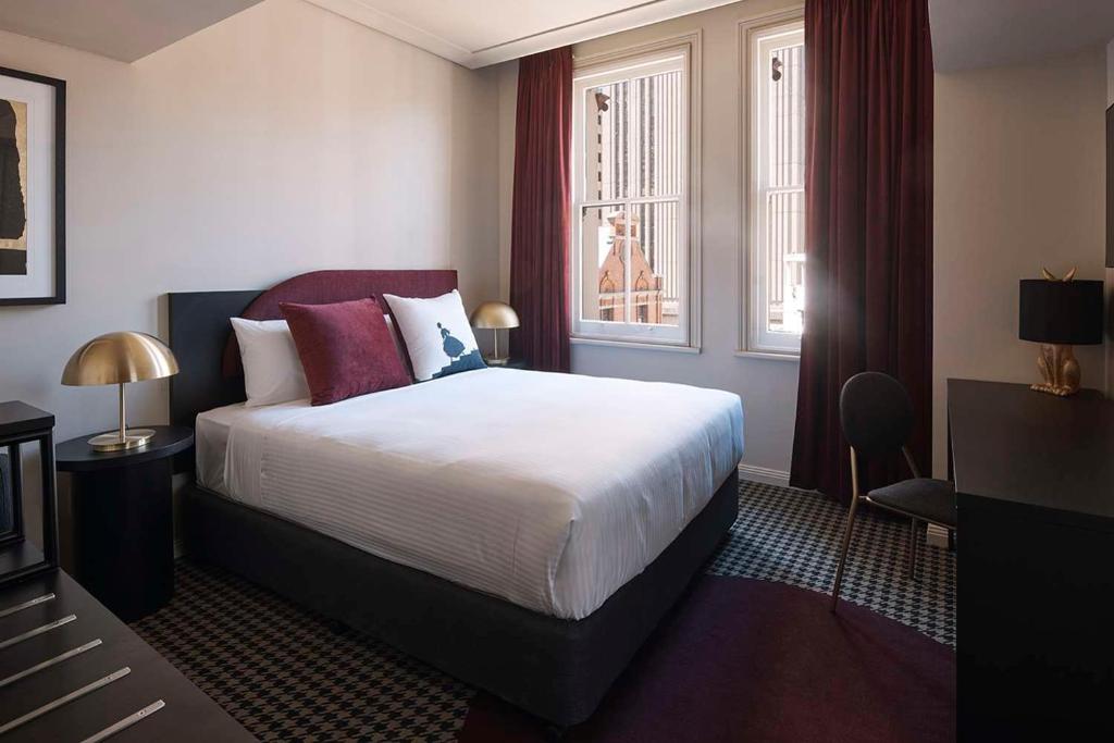 悉尼The Capitol Hotel Sydney的酒店客房设有床和窗户。