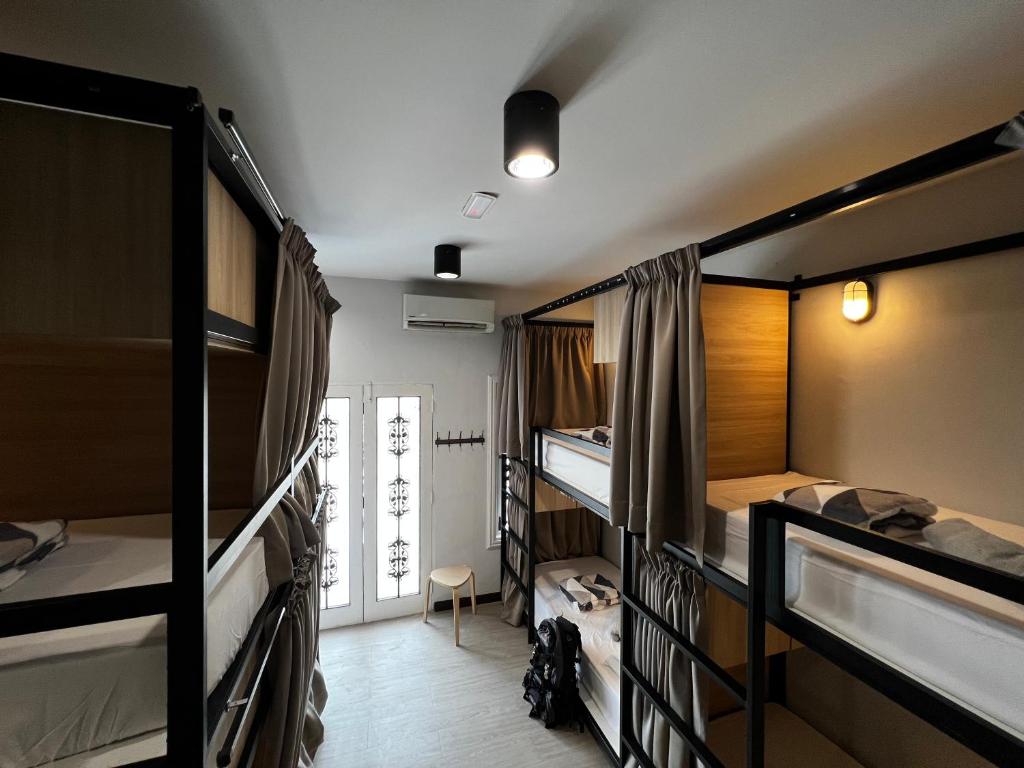 吉隆坡The Freedom Club Hostel KL的带三张双层床和走廊的客房