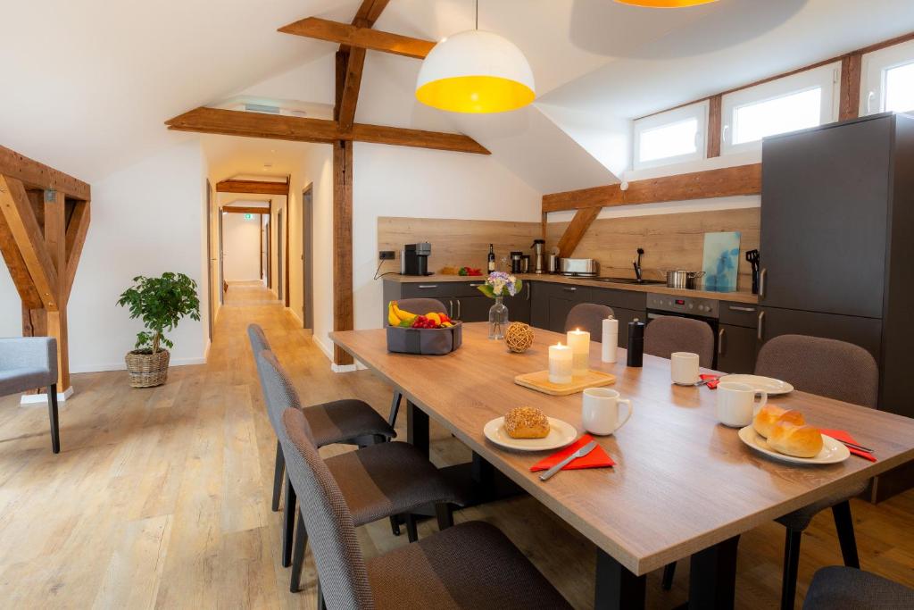 圣安德里斯伯格Lieblingsquartier St. Andreasberg的厨房以及带木桌和椅子的用餐室。
