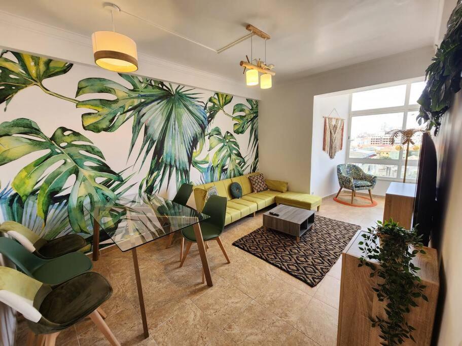 阿尔马达Cozy Apartment in central Almada w Swing Chairs的客厅的墙上挂着棕榈树壁画