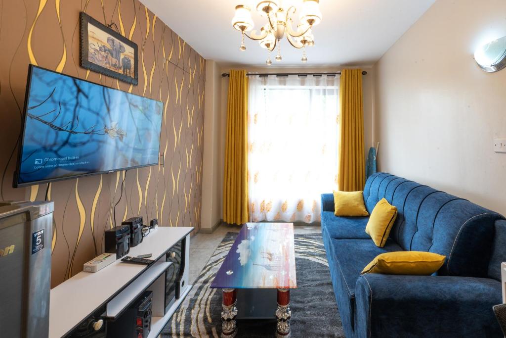 内罗毕The Bliss - Lovely 1 bedroom apartment located near TRM mall的客厅配有蓝色的沙发和电视
