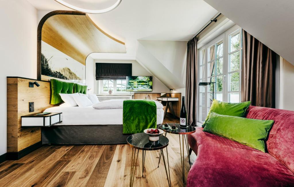 提努姆Relais & Châteaux Landhaus Stricker, Hotel des Jahres 2023的酒店客房,配有床和沙发
