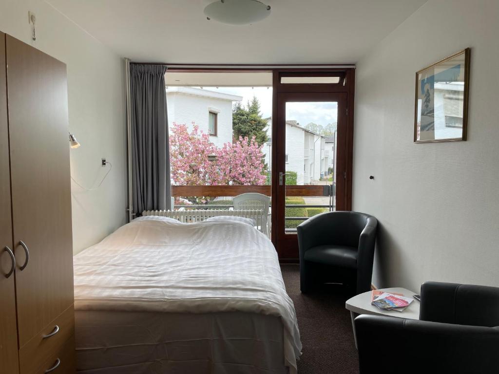 法尔肯堡马克思汽车旅馆的卧室配有床、椅子和窗户。