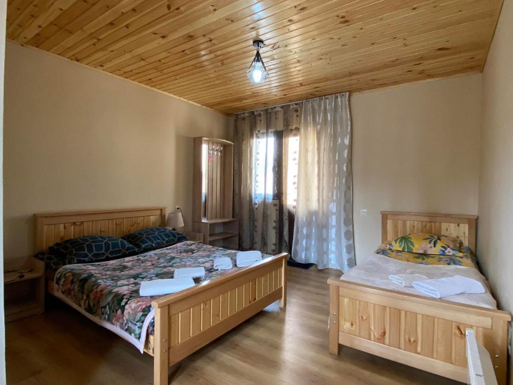 梅斯蒂亚Guesthouse Venera的一间卧室设有两张床和木制天花板