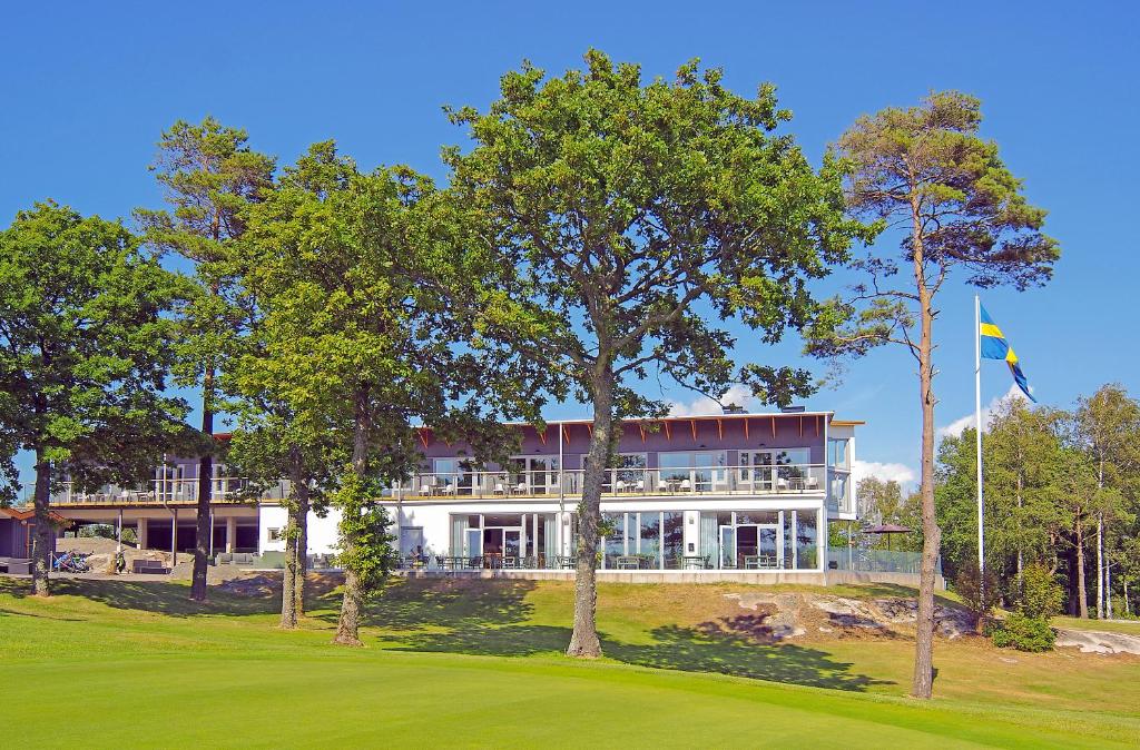 亨尼博斯特兰德Sotenäs Golfhotell的前面有树木的大白色房子