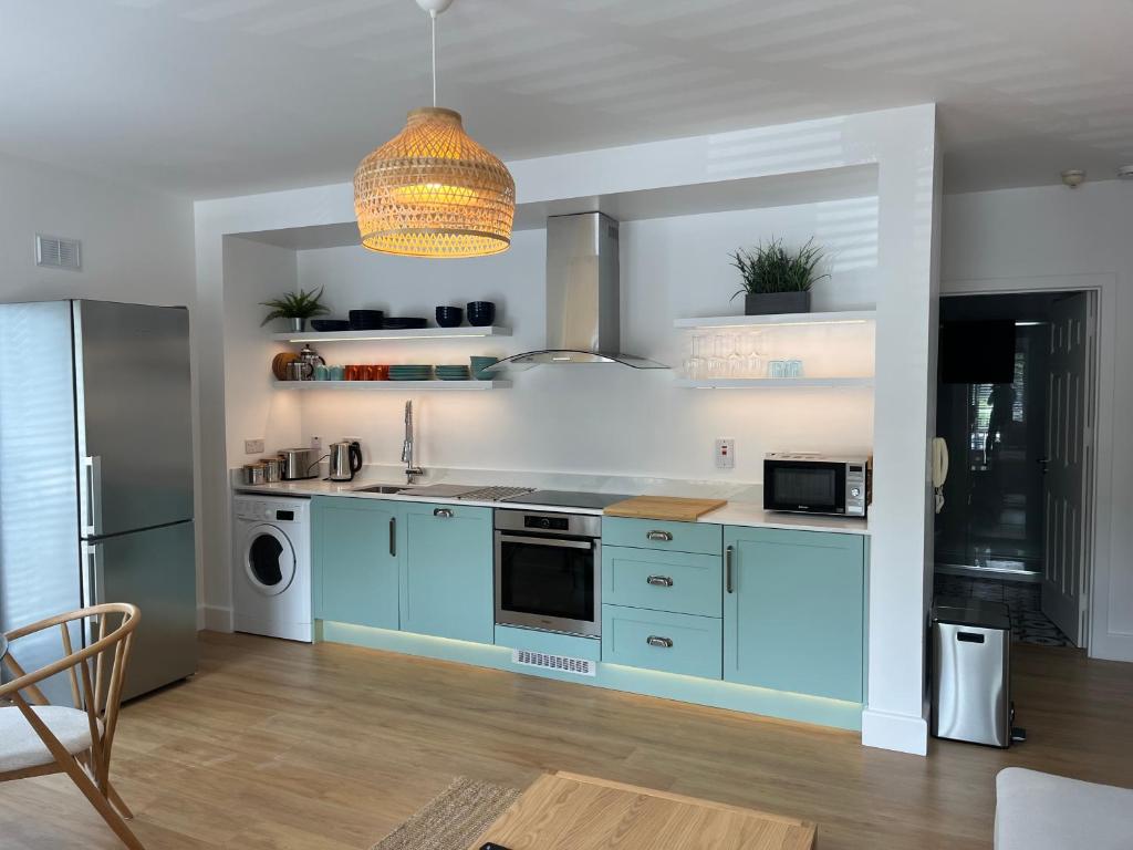 恩尼斯科西2 Bedroom Apartment Central Town Location的厨房配有蓝色橱柜和冰箱。