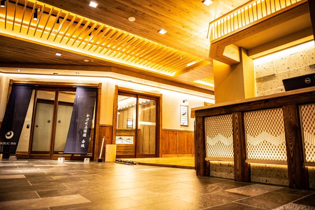 东京かぷせる旅籠 赤坂 SPABLIC INN的一座带木制天花板的建筑的大堂