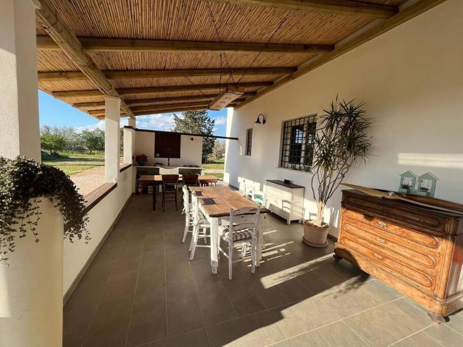桑尼科拉Residenza SA - tra mare e campagna的一个带木屋顶的庭院,配有桌椅