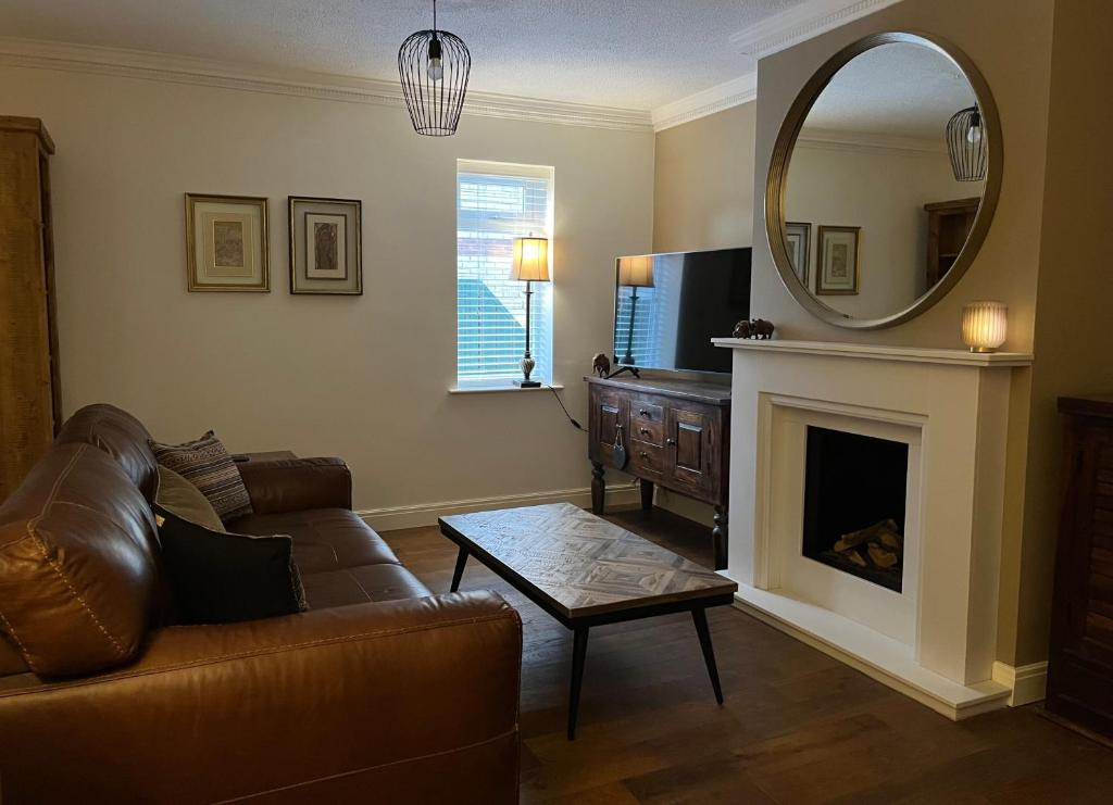 贝弗利Stunning Beverley Bungalow w Fireplace, private parking, and garden的带沙发和镜子的客厅