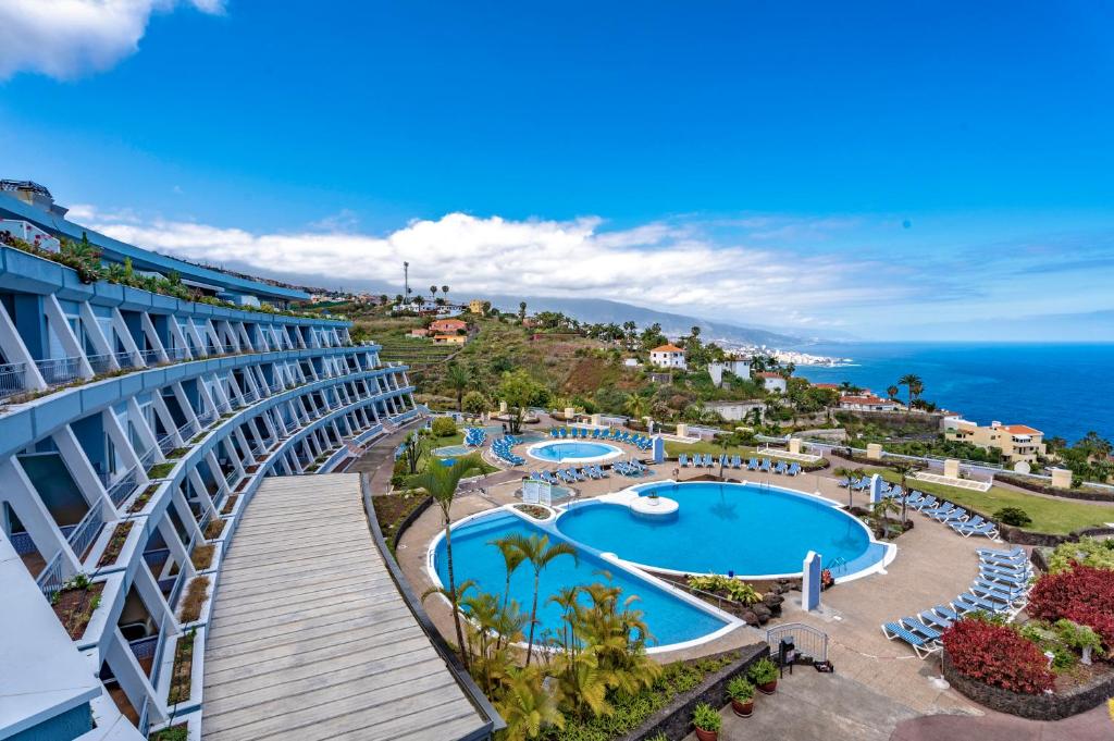 圣乌尔苏拉Coral La Quinta Park Suites的享有带游泳池和海洋的度假村的空中景致