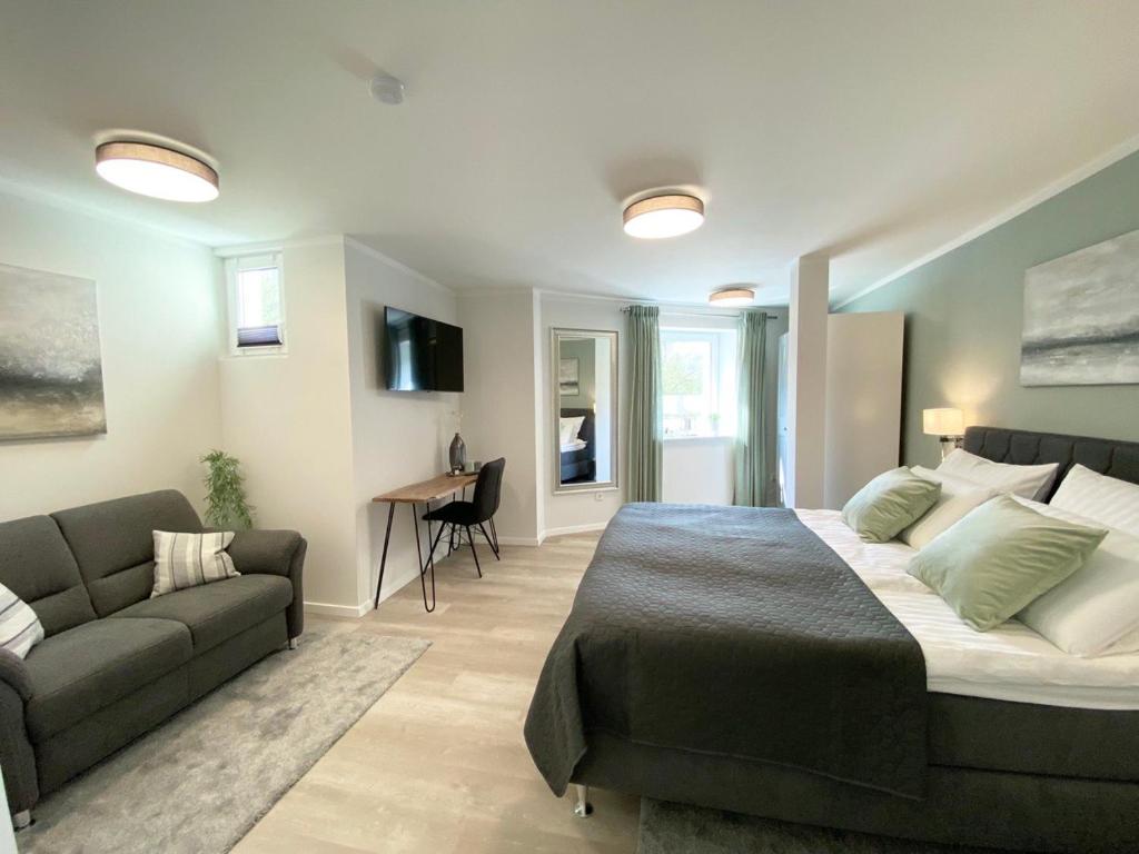 代特莫尔德QT Apartments Detmold的一间卧室配有一张大床和一张沙发