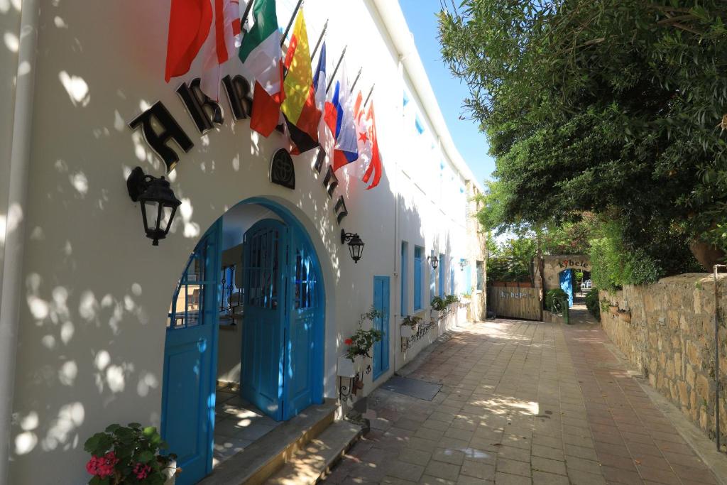 凯里尼亚Bellapais Abbey Boutique Hotel的街道上带有蓝色门和旗帜的建筑