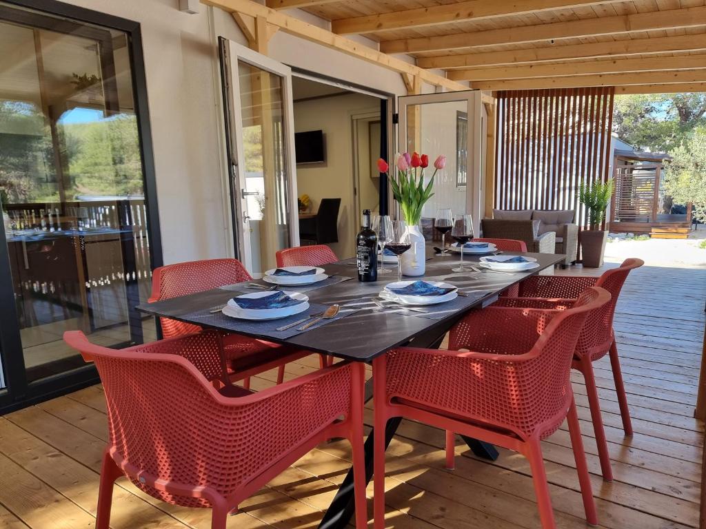 德拉格Premium mobile home SUN & JOY - Oaza Mira Camping的餐桌、红色椅子和桌椅