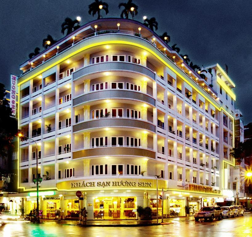 胡志明市Huong Sen Hotel的一座白色的大建筑,灯火通明
